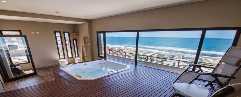 Balcón con hidromasaje, silla y vista al mar