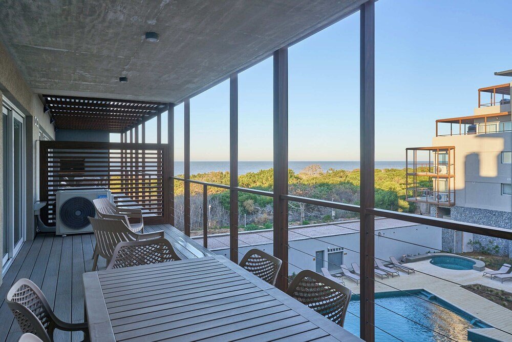 Balcón con pileta y muebles de madera