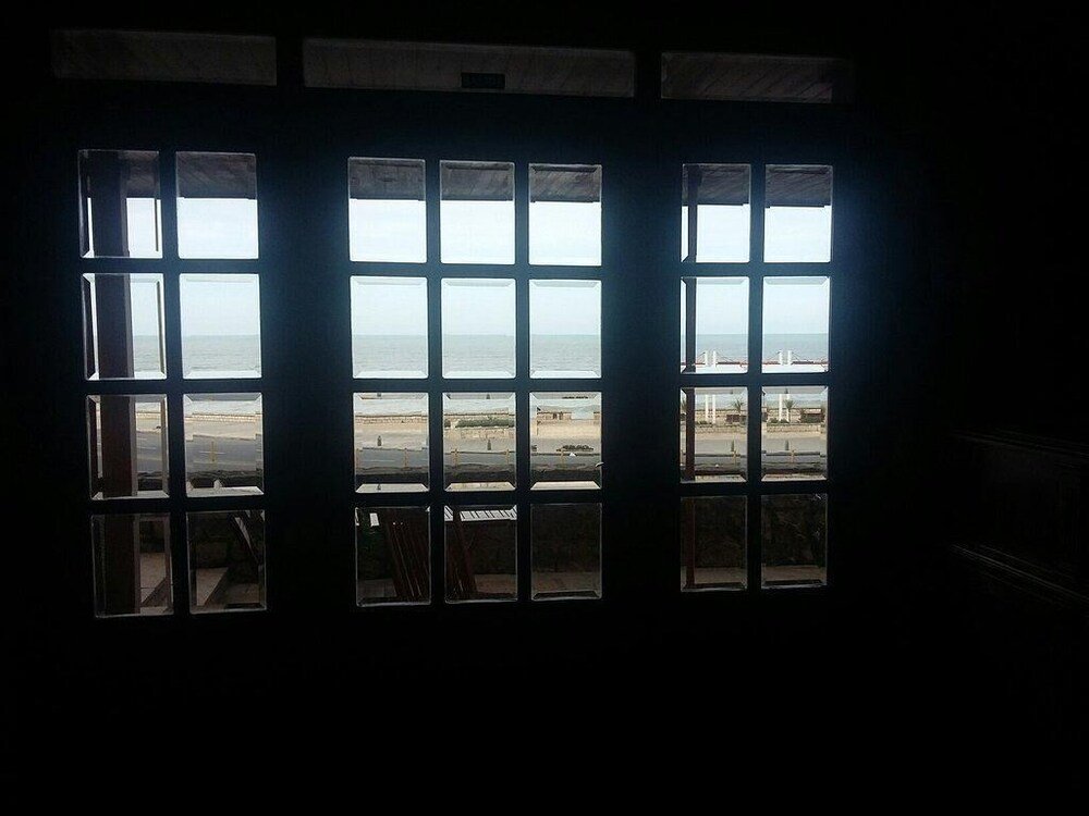 Sala con gran ventanal que da a una playa y a un puente