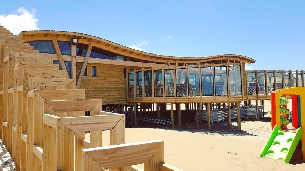 Estructura de madera con techo curvo y grandes ventanales
