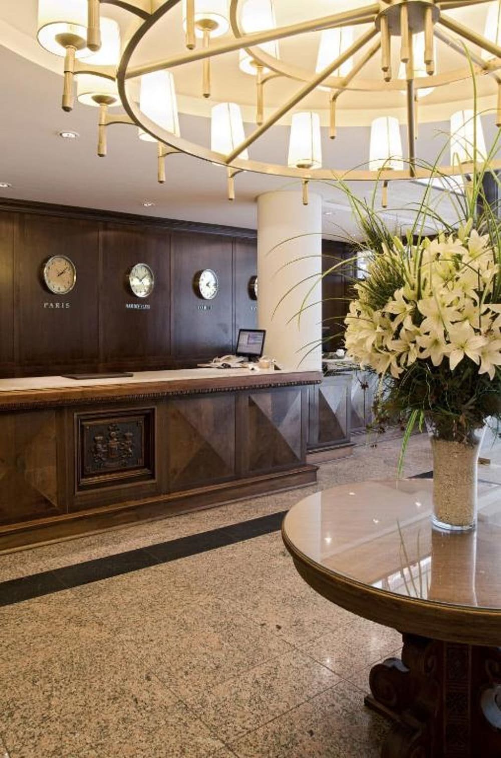 Recepción con mostrador de madera oscura y mesa con flores