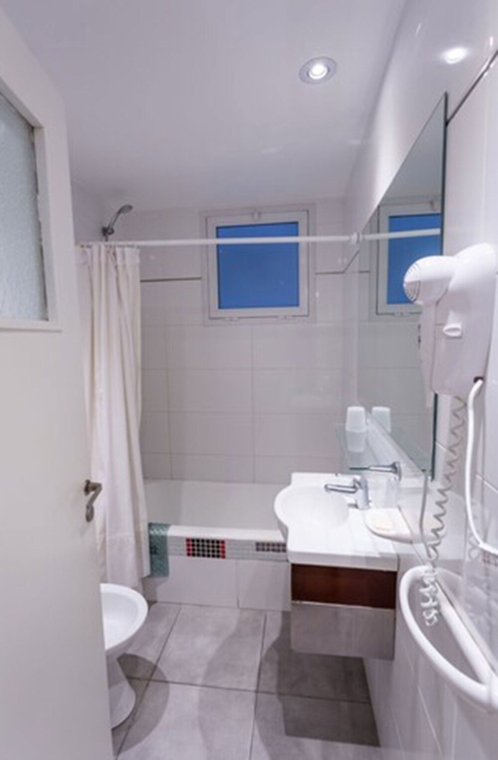Baño moderno con ducha, lavatorio y espejo