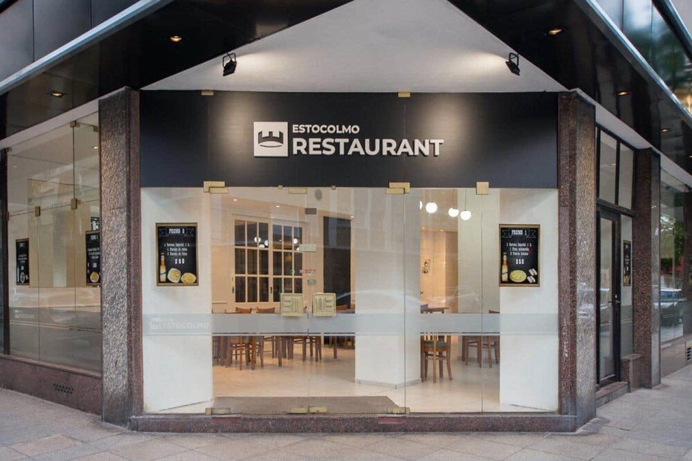 Fachada vidriada del restaurante con cartel a la vista