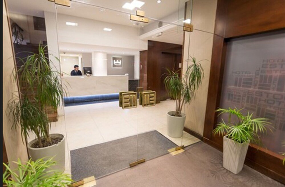 Recepción con mostrador, plantas y un espejo grande