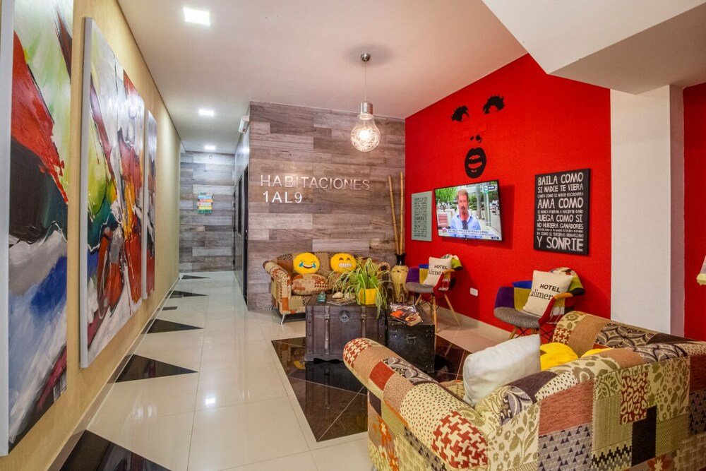 Hall de entrada con pared roja y mostrador de recepción